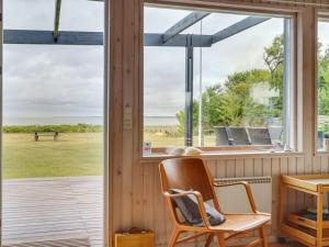 Zimmer mit einem Fenster, einem Schreibtisch und Stühlen in der Unterkunft Holiday Home Sigurd - 20m from the sea in Funen by Interhome in Middelfart
