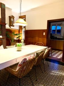 ein Esszimmer mit einem weißen Tisch und Stühlen in der Unterkunft Vakantiewoning Guesthouse MOMO in Dilsen-Stokkem