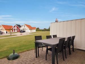 - une table et des chaises sur une terrasse avec une cour dans l'établissement Holiday Home Matleena - 200m from the sea in Funen by Interhome, à Bro