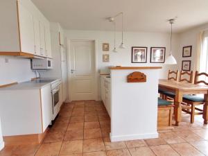 cocina con armarios blancos y mesa de madera en Holiday Home Matleena - 200m from the sea in Funen by Interhome, en Bro