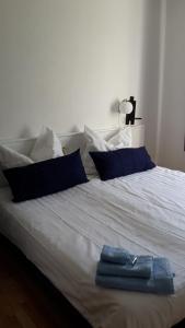 a white bed with blue pillows and a towel on it at Hotel Bad Langensalza Eichenhof in Bad Langensalza