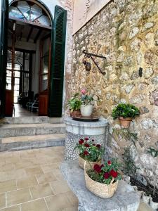 un edificio de piedra con dos cestas con flores. en Casa Bougainvillea, en Sóller