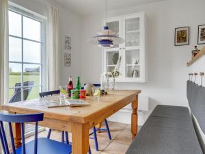 uma sala de jantar com uma mesa de madeira e cadeiras azuis em Holiday Home Askan - 200m from the sea in Funen by Interhome em Bro