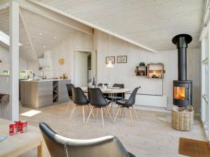 ein Wohnzimmer mit einem Tisch, Stühlen und einem Herd in der Unterkunft Holiday Home Diertje - 10m from the sea in Funen by Interhome in Otterup