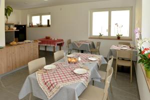 une salle à manger avec deux tables et une cuisine dans l'établissement Bed and Breakfast NAVIS, à Nave San Rocco