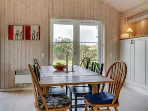 comedor con mesa de madera y sillas en Holiday Home Thala - 150m from the sea in Funen by Interhome, en Bogense