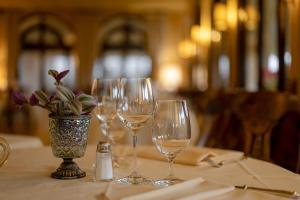 a table with wine glasses and a vase with flowers at Hotel Villa Cipriani in Asolo