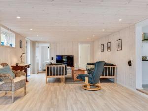 - un salon avec un canapé, des chaises et une table dans l'établissement Holiday Home Hardina - 300m from the sea in Funen by Interhome, à Martofte