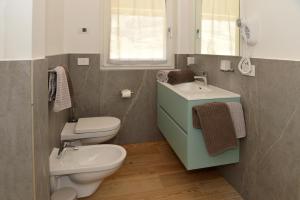 La salle de bains est pourvue de toilettes et d'un lavabo. dans l'établissement Bed and Breakfast NAVIS, à Nave San Rocco