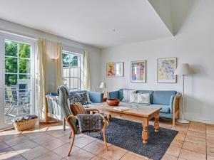ein Wohnzimmer mit einem blauen Sofa und einem Tisch in der Unterkunft Holiday Home Arwin - 250m from the sea in Funen by Interhome in Bro