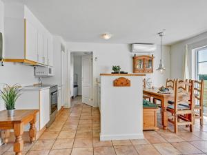 eine Küche und ein Esszimmer mit weißen Schränken und einem Tisch in der Unterkunft Holiday Home Arwin - 250m from the sea in Funen by Interhome in Bro