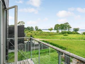 AsperupにあるHoliday Home Anny - 100m from the sea in Funen by Interhomeの水辺の景色を望むバルコニー付きの客室です。