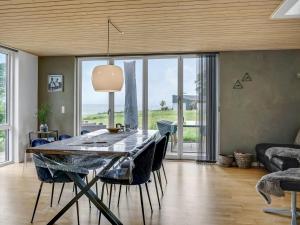 una sala da pranzo con tavolo e una grande finestra di Holiday Home Anny - 100m from the sea in Funen by Interhome ad Asperup