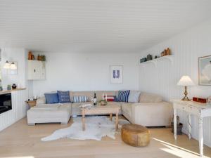 a living room with a couch and a table at Holiday Home Pellervo - 20m from the sea in Funen by Interhome in Assens
