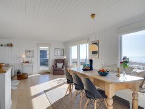 a living room with a wooden table and chairs at Holiday Home Pellervo - 20m from the sea in Funen by Interhome in Assens