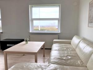 a living room with a couch and a table and a window at Holiday Home Susia - 200m from the sea in Funen by Interhome in Middelfart