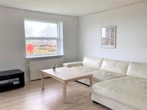 a living room with a white couch and a table at Holiday Home Susia - 200m from the sea in Funen by Interhome in Middelfart