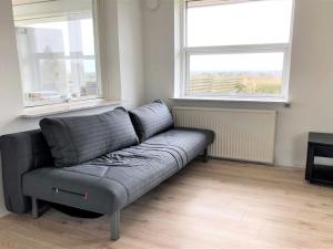 a couch in a living room with two windows at Holiday Home Susia - 200m from the sea in Funen by Interhome in Middelfart