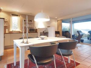 uma cozinha e sala de jantar com mesa e cadeiras em Holiday Home Laila - 5m from the sea in Funen by Interhome em Middelfart