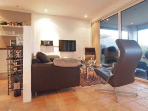 uma sala de estar com um sofá e uma cadeira em Holiday Home Laila - 5m from the sea in Funen by Interhome em Middelfart