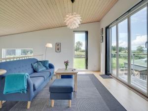 salon z niebieską kanapą i stołem w obiekcie Holiday Home Lyly - 100m from the sea in Funen by Interhome w mieście Asperup