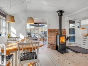 een keuken en eetkamer met een houtkachel bij Holiday Home Loella - 35m from the sea in Funen by Interhome in Svendborg