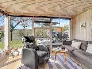 a living room with a couch and a table at Holiday Home Loella - 35m from the sea in Funen by Interhome in Svendborg