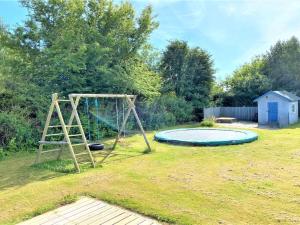 een speeltuin in een tuin met een trampoline bij Holiday Home Alrich - 500m from the sea in Funen by Interhome in Svendborg
