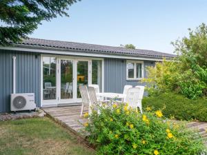 een patio met witte stoelen en een tafel op een terras bij Holiday Home Alrich - 500m from the sea in Funen by Interhome in Svendborg