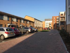 a city street with parked cars and buildings at Greenwich House in London