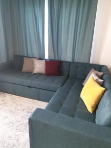 Sharm Hills في شرم الشيخ: أريكة زرقاء مع وسائد عليها في غرفة المعيشة