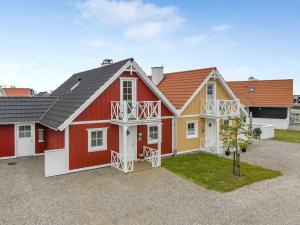 una casa roja y amarilla con patio en Holiday Home Bleike - 250m from the sea in Funen by Interhome, en Bro