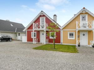 una casa roja y blanca con un coche aparcado en la entrada en Holiday Home Bleike - 250m from the sea in Funen by Interhome, en Bro