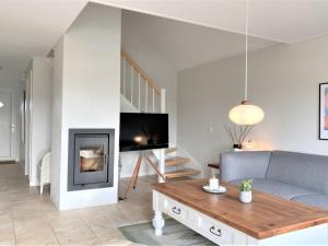 ein Wohnzimmer mit einem Sofa und einem Kamin in der Unterkunft Holiday Home Eike - 250m from the sea in Funen by Interhome in Bro