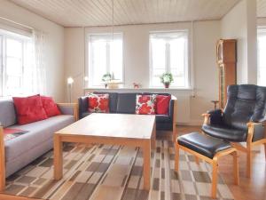 uma sala de estar com um sofá, uma mesa e cadeiras em Holiday Home Store - 700m from the sea in Funen by Interhome em Ebberup