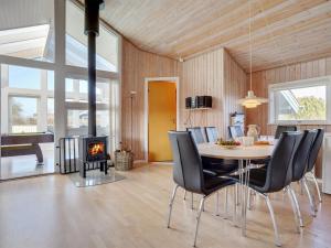 a dining room with a table and chairs and a fireplace at Holiday Home Dunya - 400m from the sea in Funen by Interhome in Assens