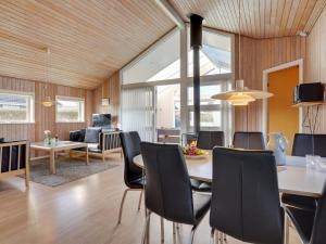 a dining room and living room with a table and chairs at Holiday Home Dunya - 400m from the sea in Funen by Interhome in Assens