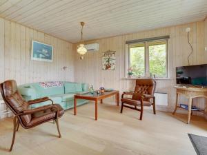 sala de estar con sofá, mesa y sillas en Holiday Home Rəzvan - 120m from the sea in Funen by Interhome, en Vedelshave