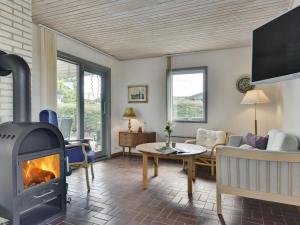 ein Wohnzimmer mit einem Kamin und einem Sofa in der Unterkunft Holiday Home Rise - 250m from the sea in Funen by Interhome in Bøjden