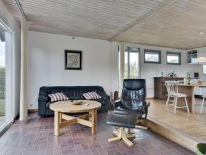 ein Wohnzimmer mit einem Sofa und einem Tisch in der Unterkunft Holiday Home Rise - 250m from the sea in Funen by Interhome in Bøjden