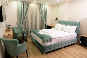 1 dormitorio con 1 cama azul y 1 silla en Loss Hotel, en Beylikduzu