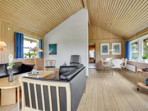 een woonkamer met een bank en een tafel bij Holiday Home Janne - 400m from the sea in Funen by Interhome in Bogense