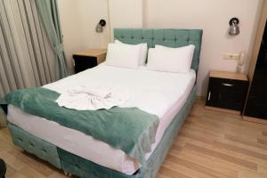 a bedroom with a large bed with a green headboard at Loss Hotel in Beylikduzu