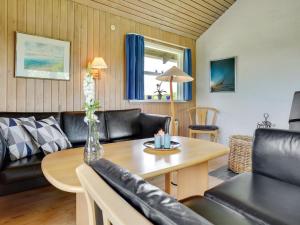 een woonkamer met lederen meubels en een tafel bij Holiday Home Janne - 400m from the sea in Funen by Interhome in Bogense