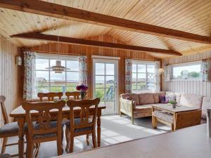 een woonkamer met een tafel en een bank bij Holiday Home Herulf - 100m from the sea by Interhome in Bogentved