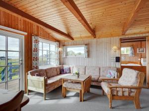 een woonkamer met een bank en een tafel bij Holiday Home Herulf - 100m from the sea by Interhome in Bogentved