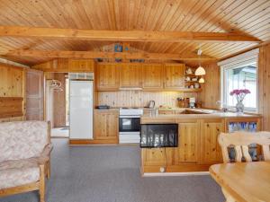 een grote keuken met houten kasten en een koelkast bij Holiday Home Herulf - 100m from the sea by Interhome in Bogentved