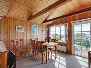 een eetkamer met een tafel en stoelen bij Holiday Home Herulf - 100m from the sea by Interhome in Bogentved +22 foto's