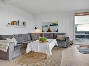 ein Wohnzimmer mit einem Sofa und einem Tisch in der Unterkunft Holiday Home Akseline - 20m from the sea in Funen by Interhome in Assens
