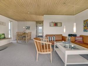 een woonkamer met een bank en een tafel bij Holiday Home Undine - 300m from the sea in Funen by Interhome in Middelfart